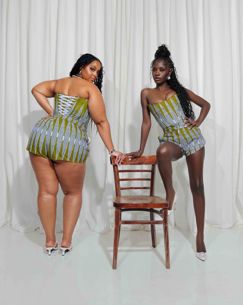 Vibrant African-inspired corset tops with bold geometric patterns, worn by two confident models in front of a plain white backdrop.