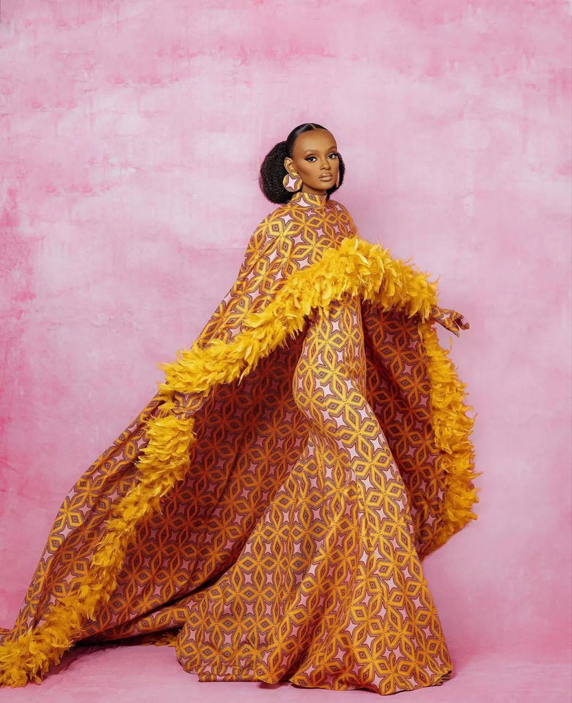 Vibrant yellow and orange African print dress with flowing feathered details, showcasing a bold and stylish fashion statement.