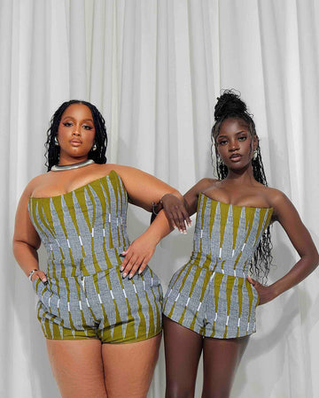 Bold and vibrant African print rompers worn by two stylish young women against a white backdrop.