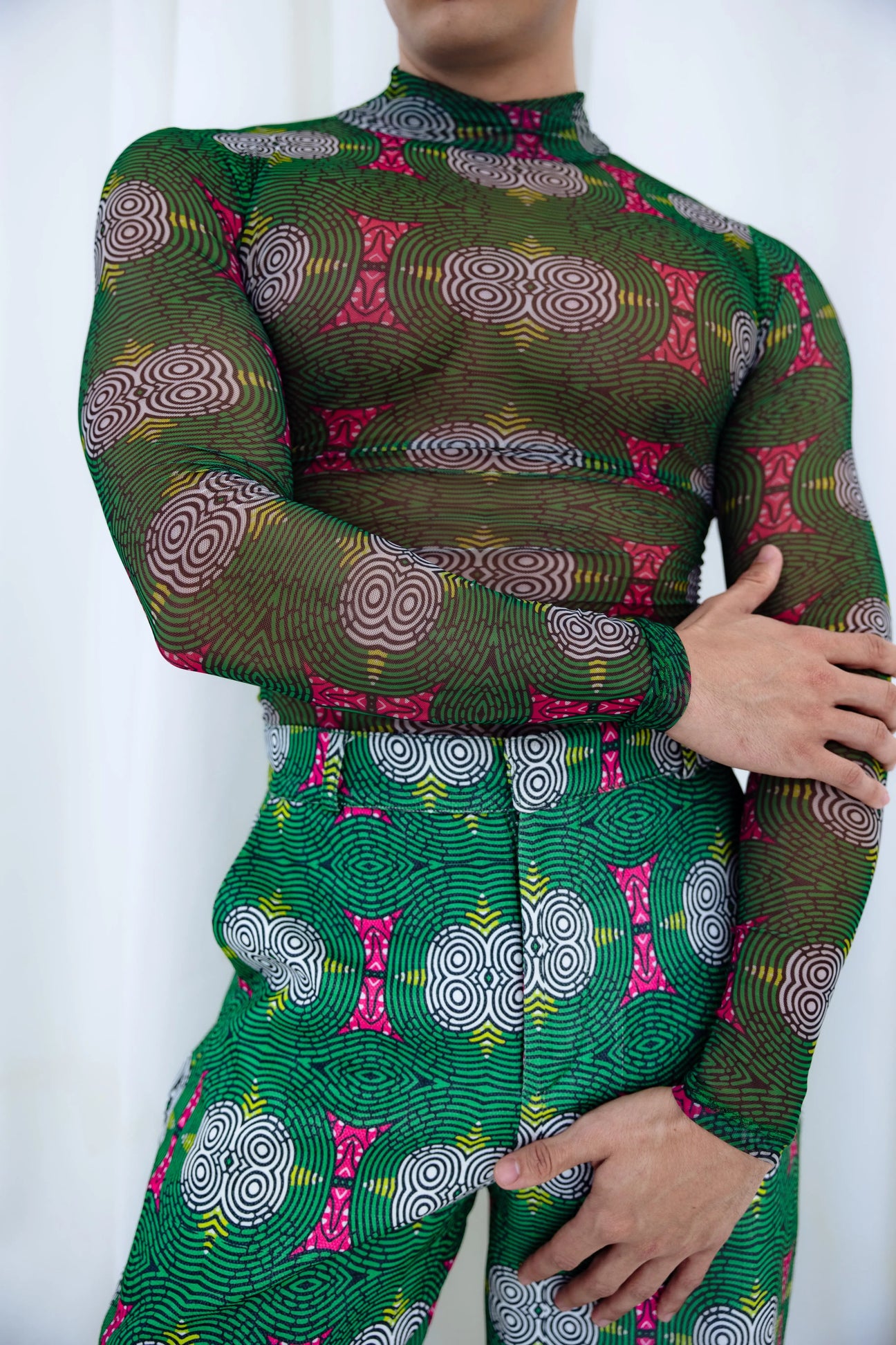 Vibrant green African mesh top with bold pink and black pattern, showcasing the unique and stylish flair of African fashion.