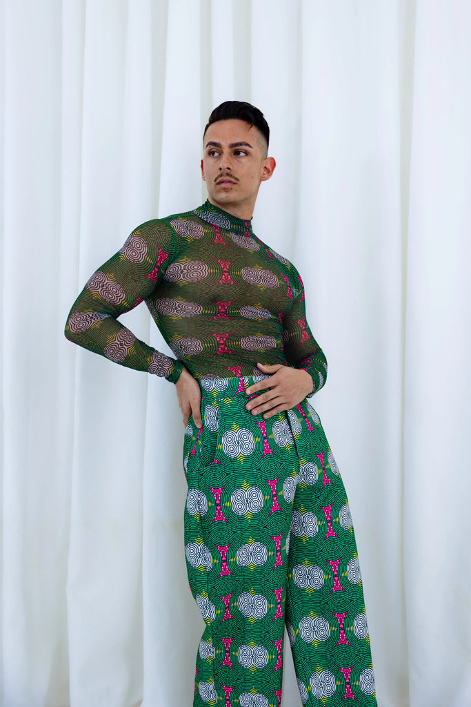 Stylish African print long sleeve shirt and coordinating patterned pants worn by a male model in a studio setting with a white background.
