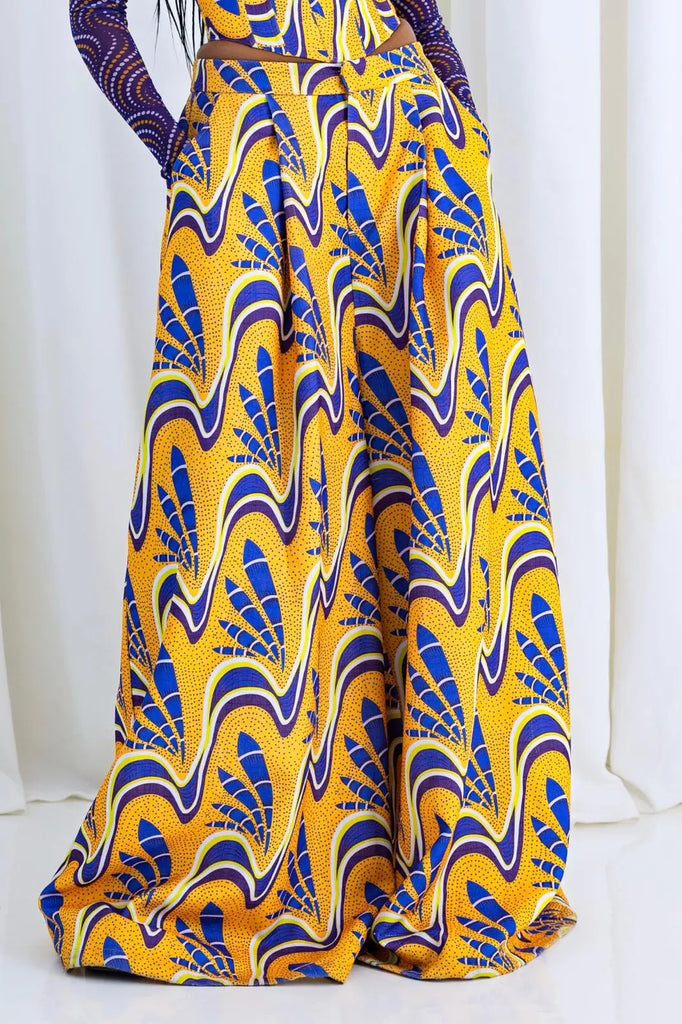 Vibrant African print palazzo pants with a vivid yellow and blue swirling pattern, showcasing the brand's culturally inspired designs.