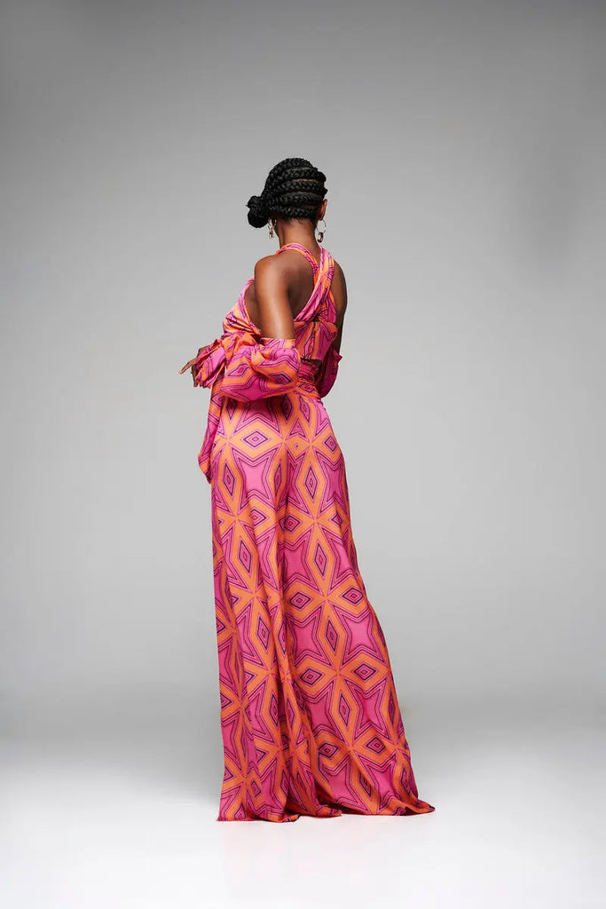 Vibrant African print maxi dress with intricate geometric patterns, featuring a low-cut back and bold pink and orange color scheme.